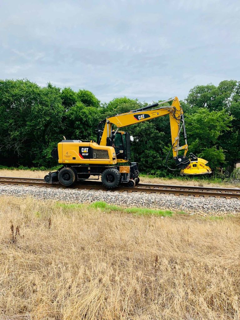 railroad vegetation management being performed on railway with a CAT machine